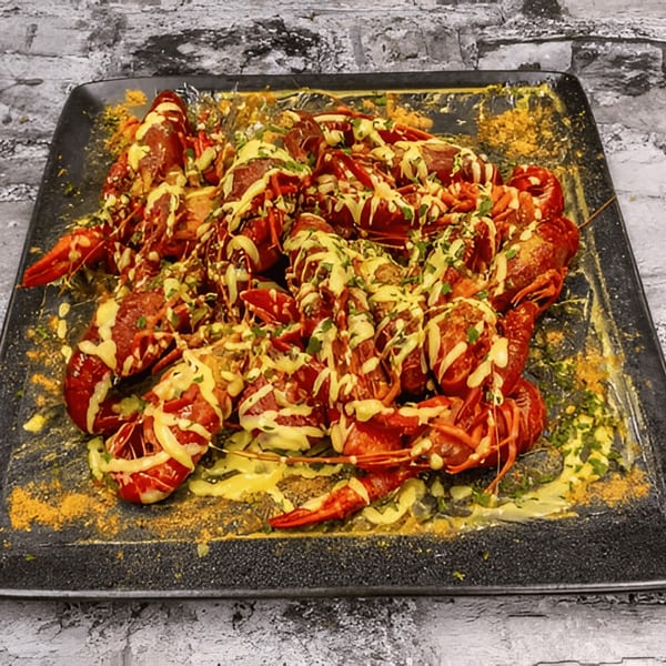 A platter of G'Ville Seafood N' Chicken's crawfish, drizzled with sauce and sprinkled with herbs.