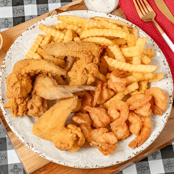 A platter of G'Ville Seafood N' Chicken fried shrimp, fried fish, fried chicken wings, and crinkle-cut fries.